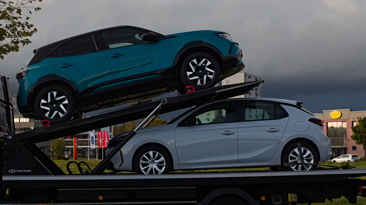 Two cars loaded onto the deck of a car transporter truck