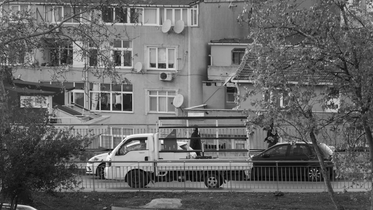 Urban street scene with a pickup truck and residential building