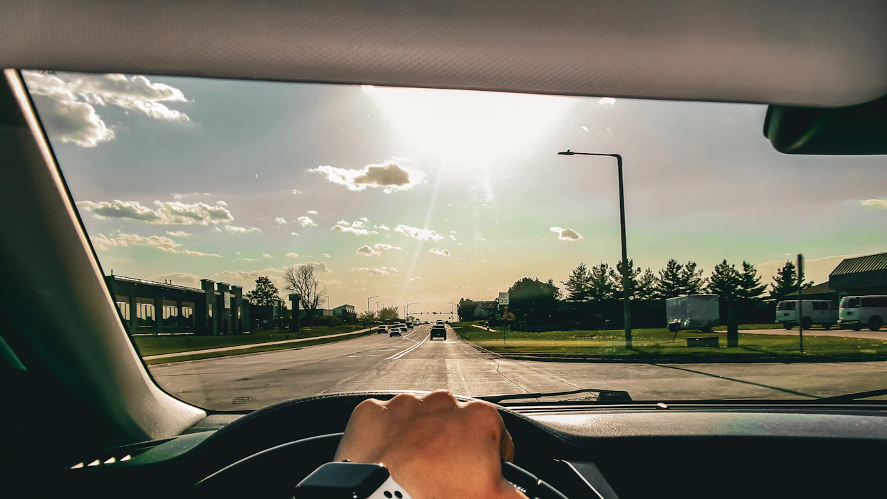 The view forward from the driver’s seat, hands on the wheel and an open road ahead